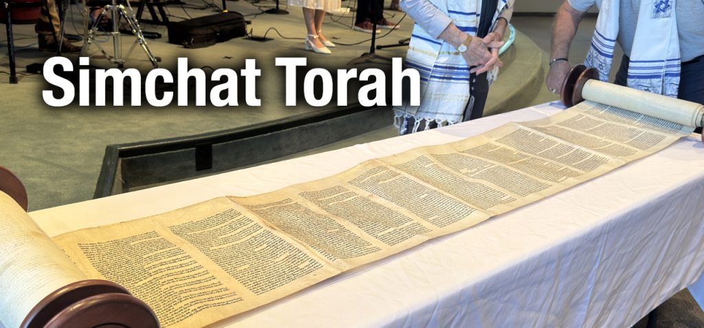 Torah scroll unrolled on a table for the Simchat Torah celebration